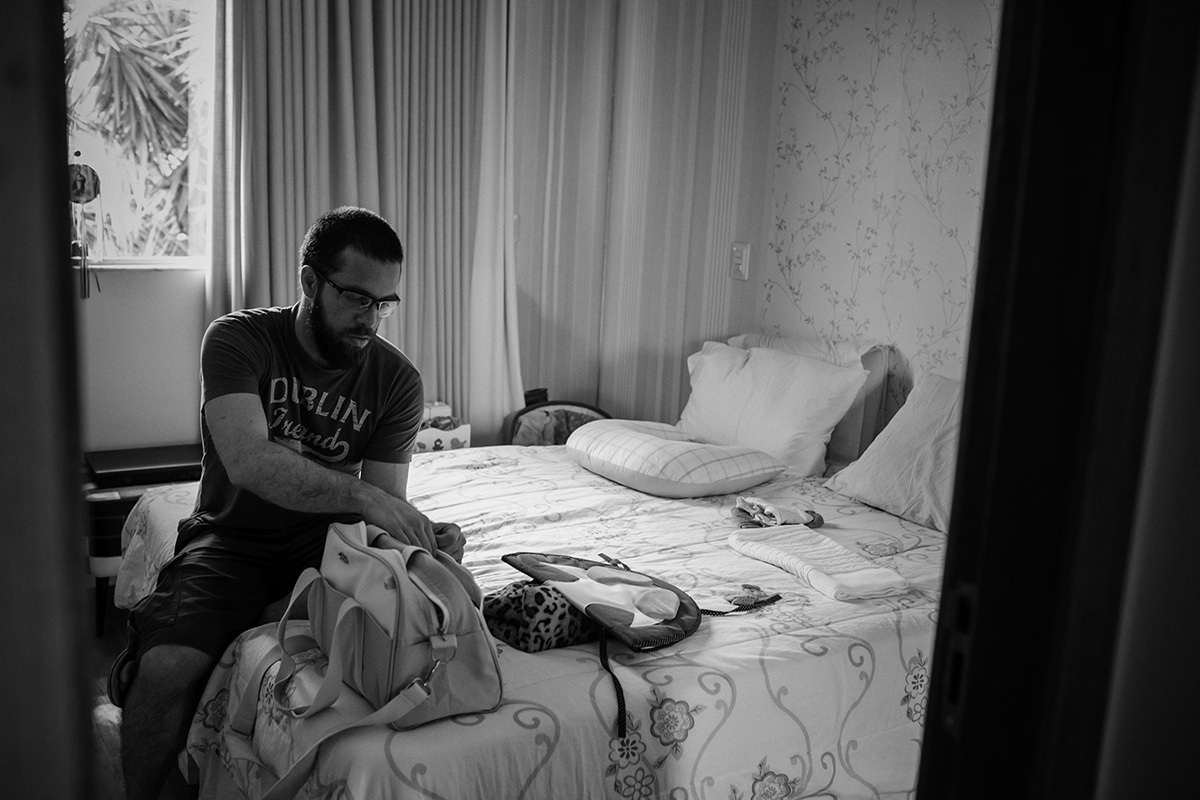 pai arrumando bolsa do bebê para sair