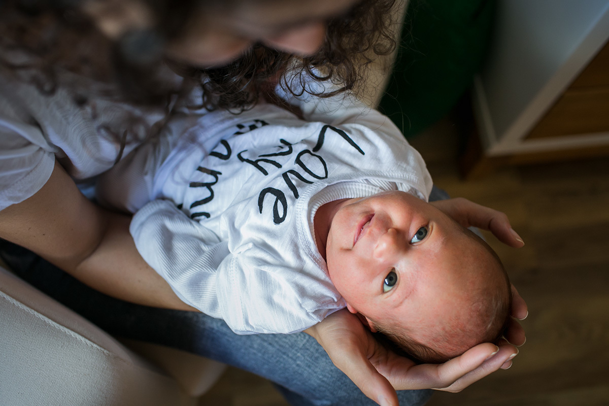 bebê sorrindo após ter sido amamentar em foto de Adriana Costa