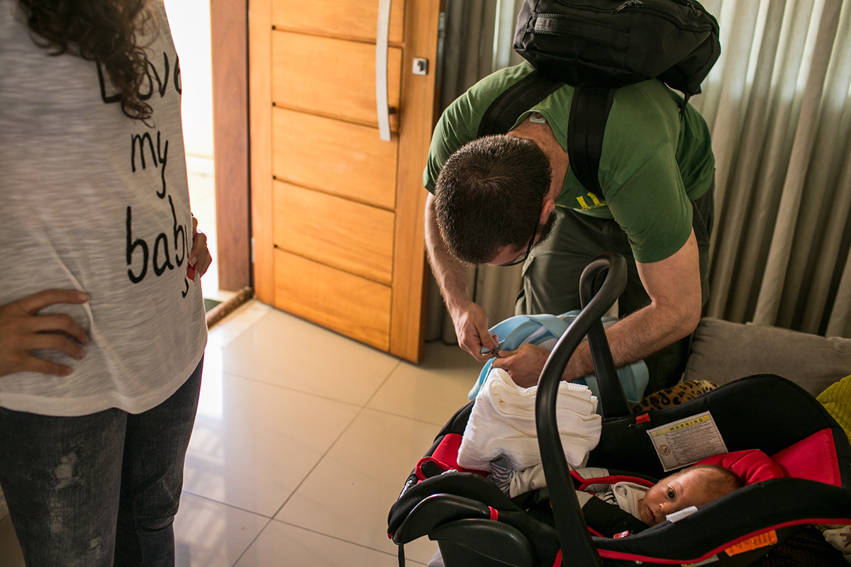 pai e mãe preparando seu filho para sair