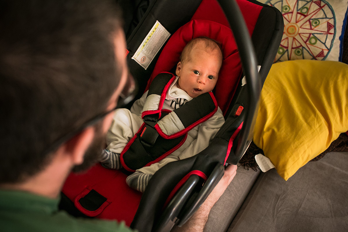 bebê sendo colocado na cadeirinha do carro
