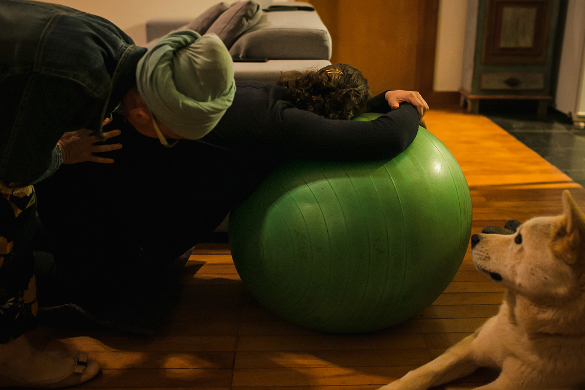 foto de Adriana Costa do cão observando a gestante recebendo massagem da doula em um momento de contração