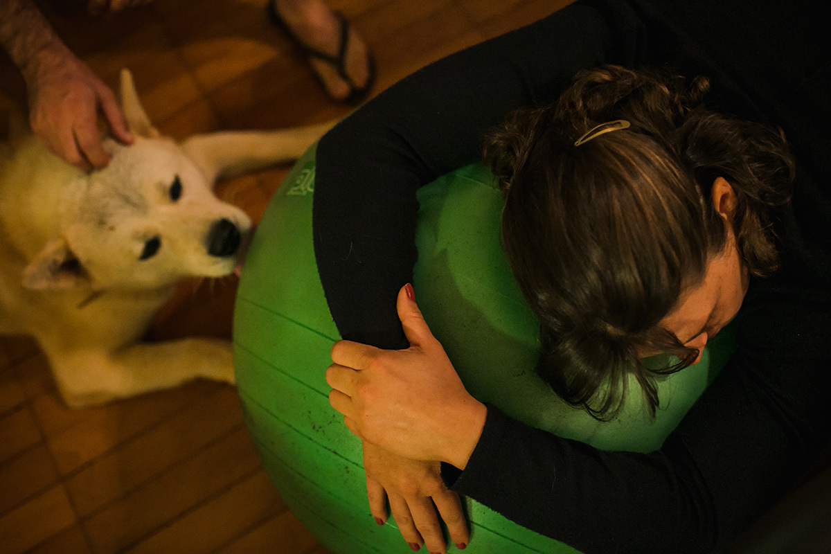 cão lambendo a bola de pilates usada pela gestante para aliviar a dor da contração em foto feita por Adriana Costa