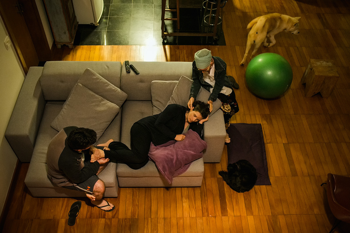 gestante recebendo massagens da doula e do marido durante um parto domiciliar, por Adriana Costa