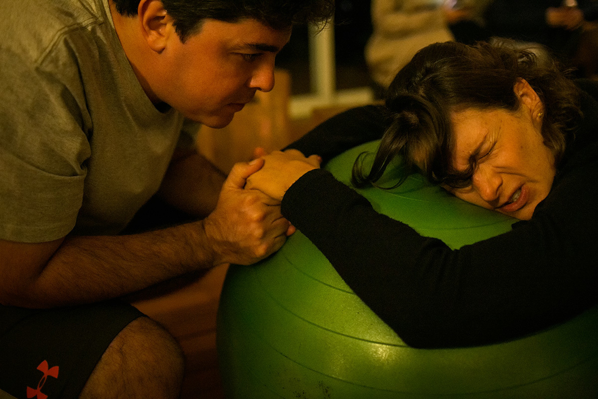 marido dando as mãos a sua esposa durante um momento de contração