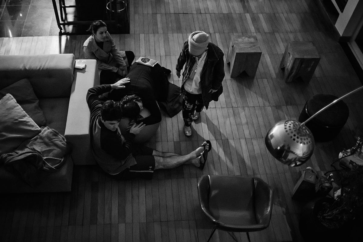 gestante sendo acompanhada pelo marido, doula e enfermeira obstétrica durante seu trabalho de parto, por adrianacostafotos