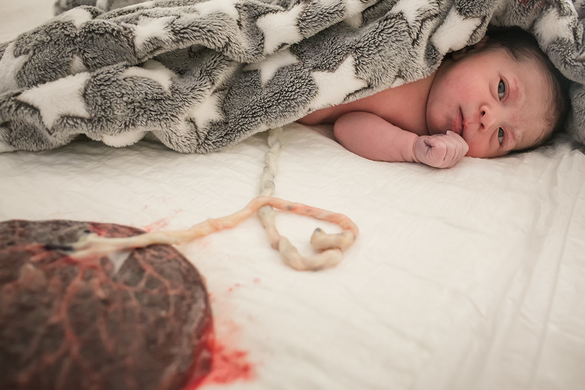 mãe amamentando sua filha pela primeira vez em foto de Adriana Costa