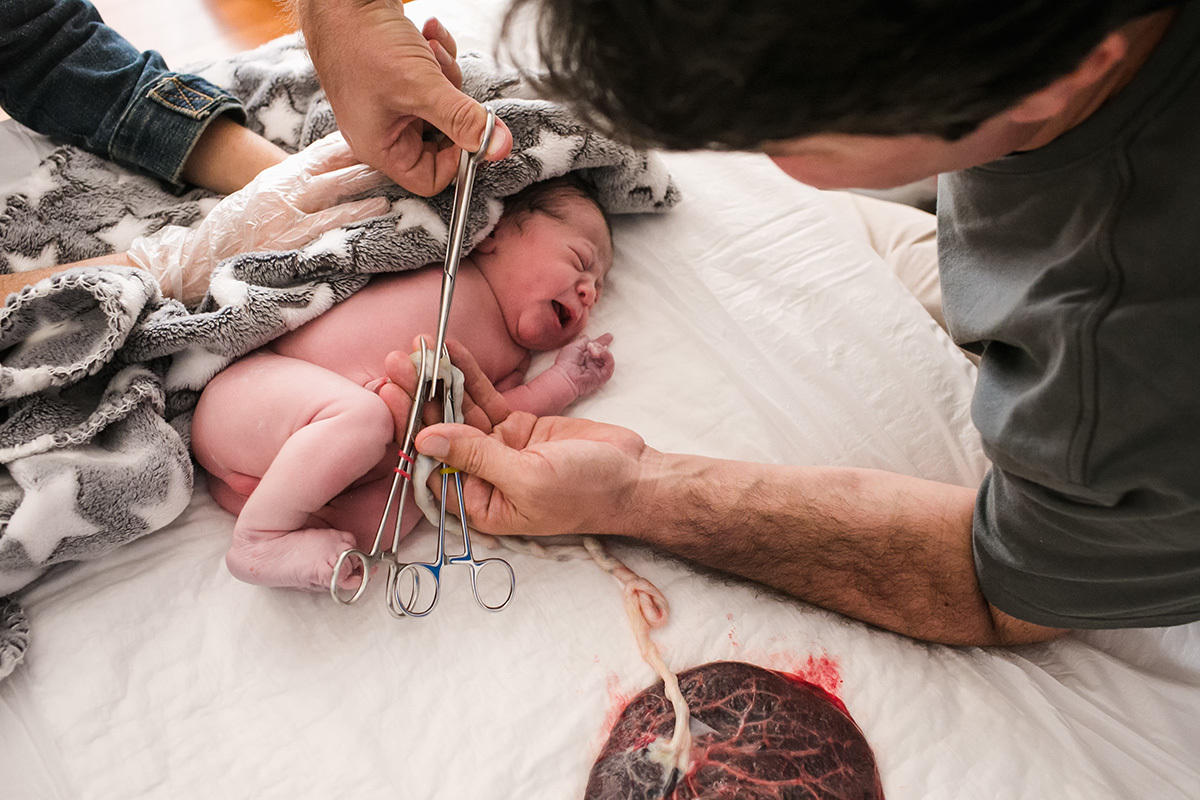 Adriana Costa fotografou o pai cortando o cordão umbilical de sua filha em casa