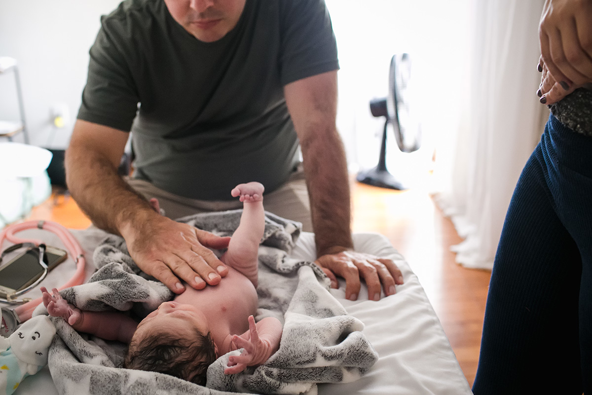 pai aprendendo a vestir a sua filha, por Adriana Costa