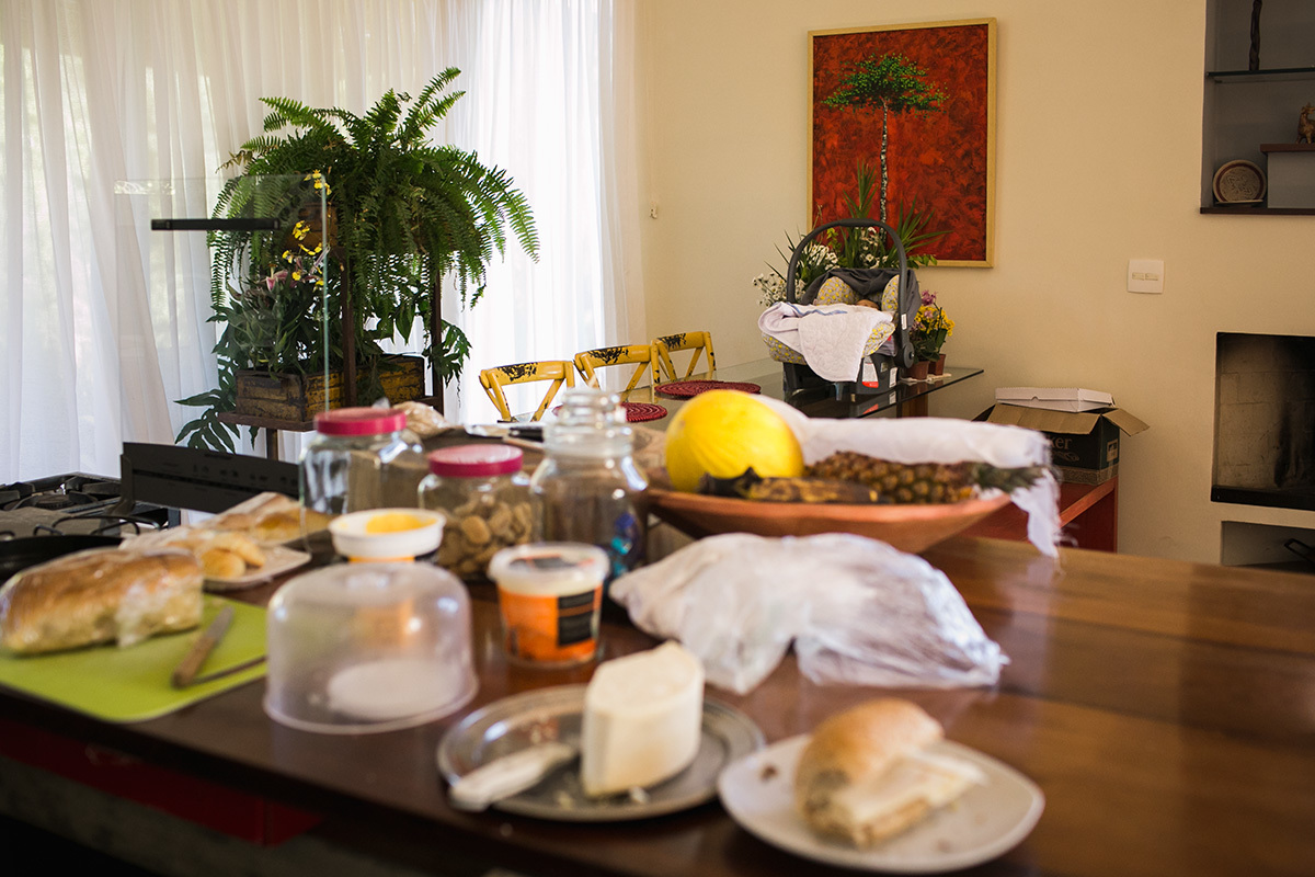 bebê dormindo no bebê conforto, sobre a mesa, na hora do café da manhã, em foto de Adriana Costa