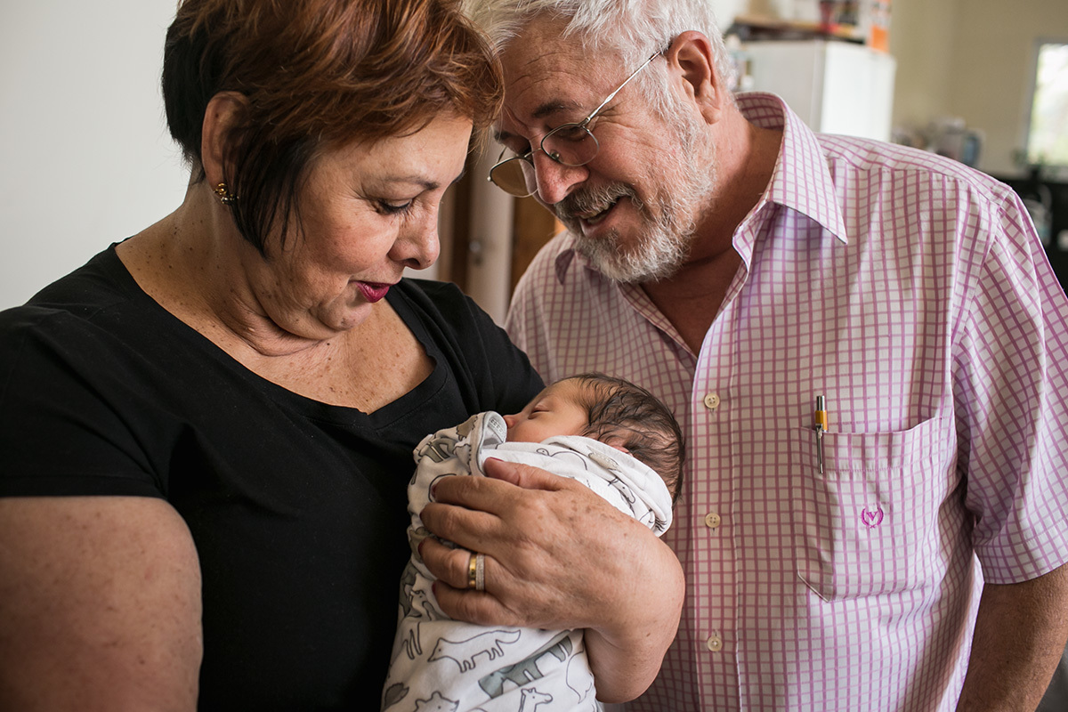 avós admirando a neta recém-nascida