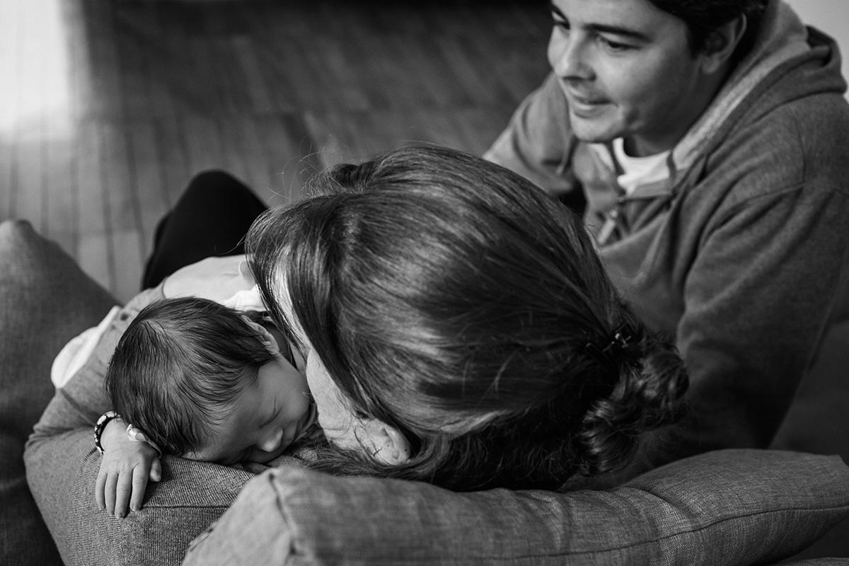 bebê dormindo após amamentar sendo admirada pelo pai, por Adriana Costa