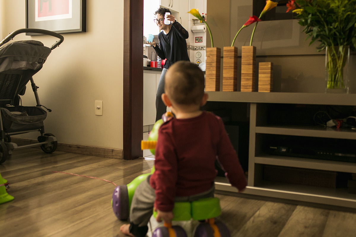 foto de Adriana Costa da mãe mostrando a mamadeira para o seu filho