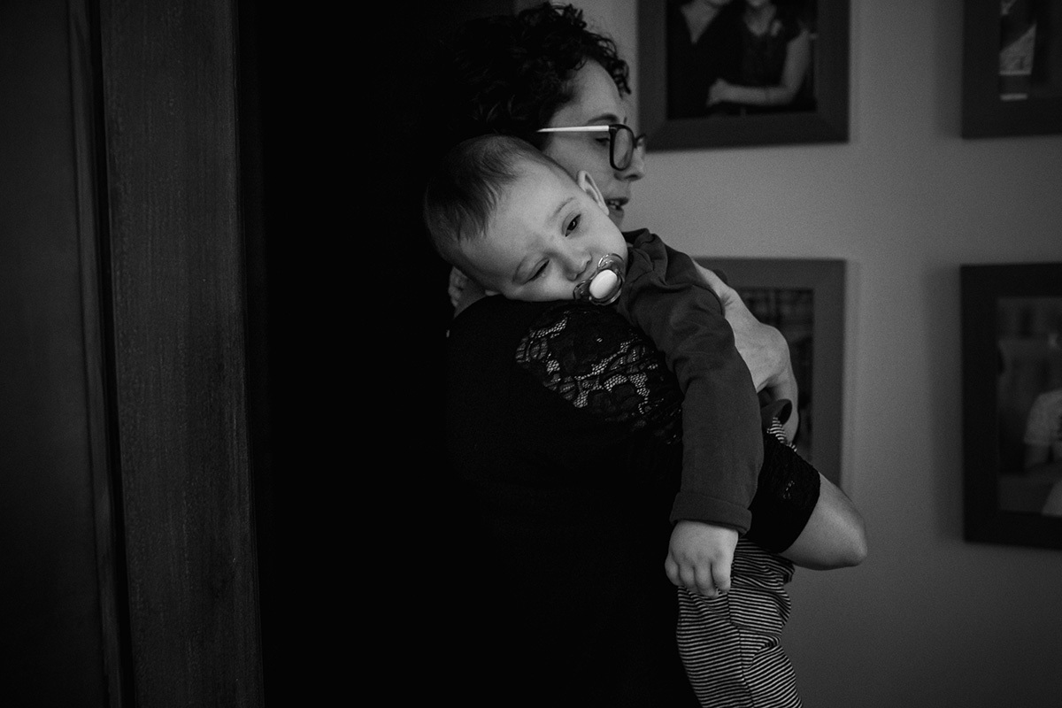 bebê quase dormindo no colo da mãe na foto de Adriana Costa