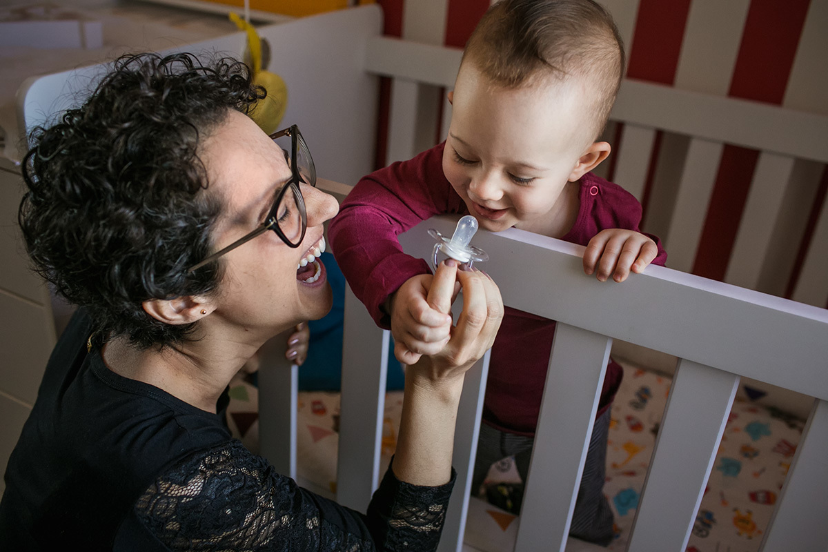 mãe e filho rindo após ele acabar de acordar, por Adriana Costa