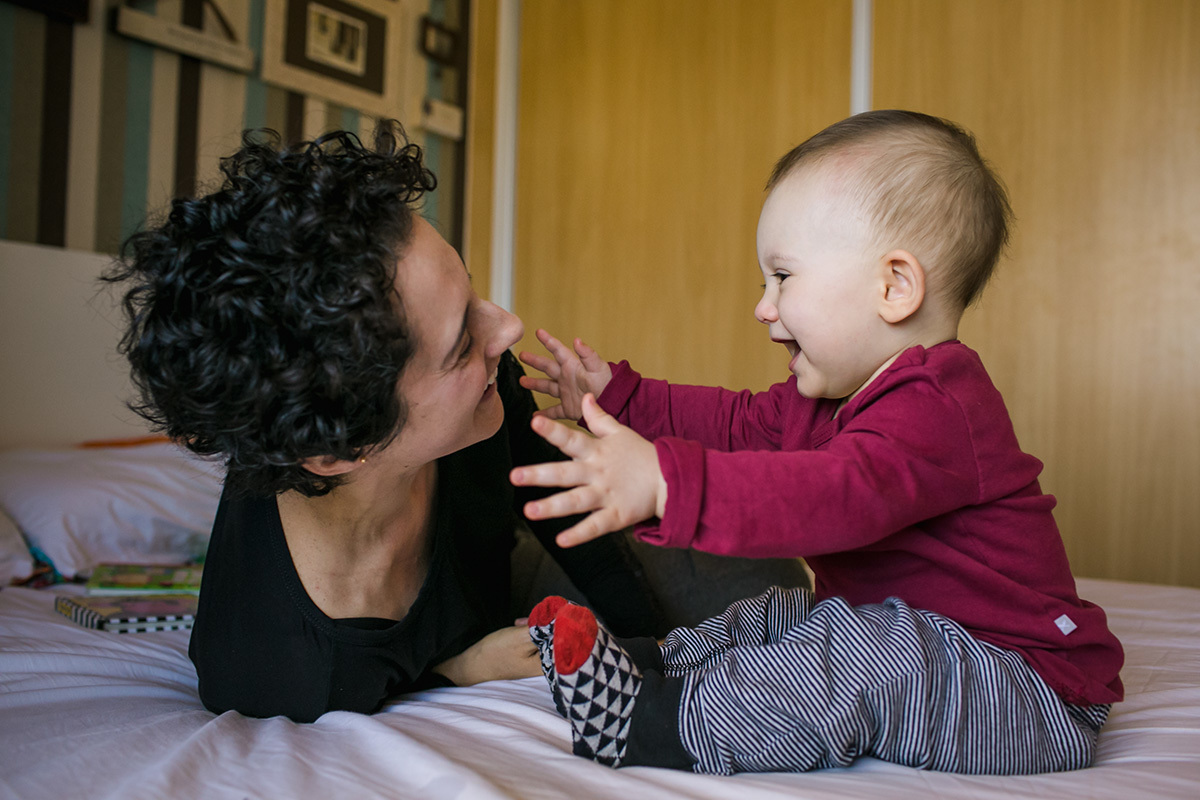 bebê feliz dando os bracinhos para a mãe em foto de Adriana Costa