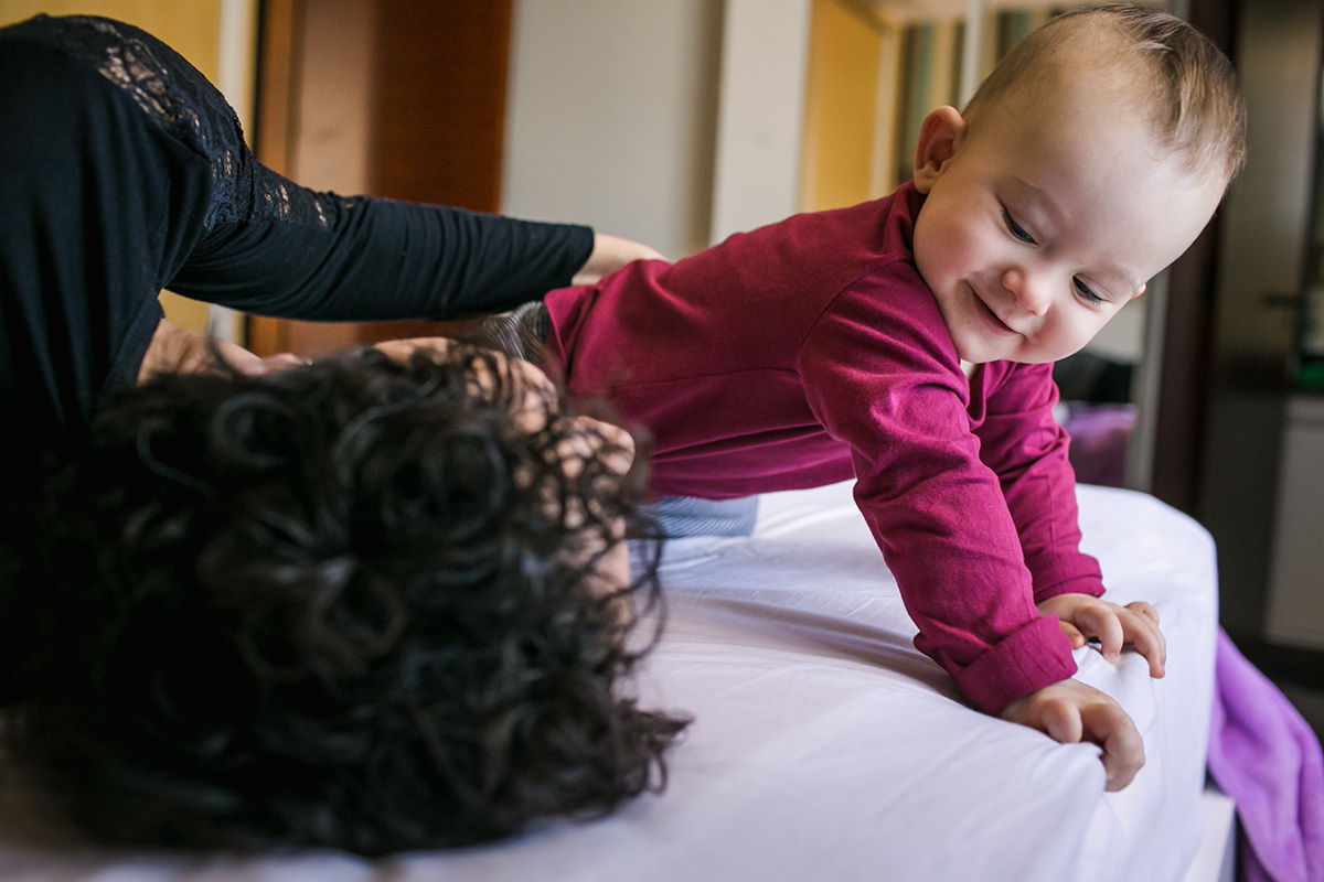 bebê brincando com a mãe na cama