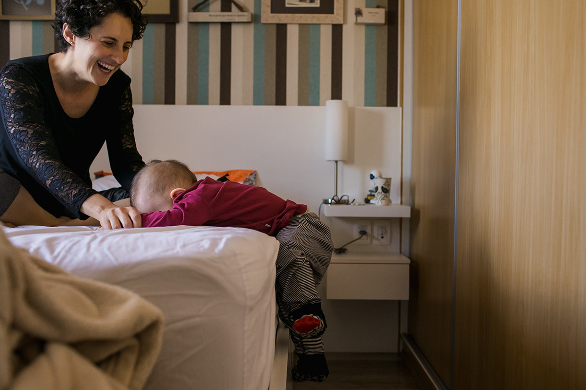 bebê descendo da cama com a ajuda da mãe