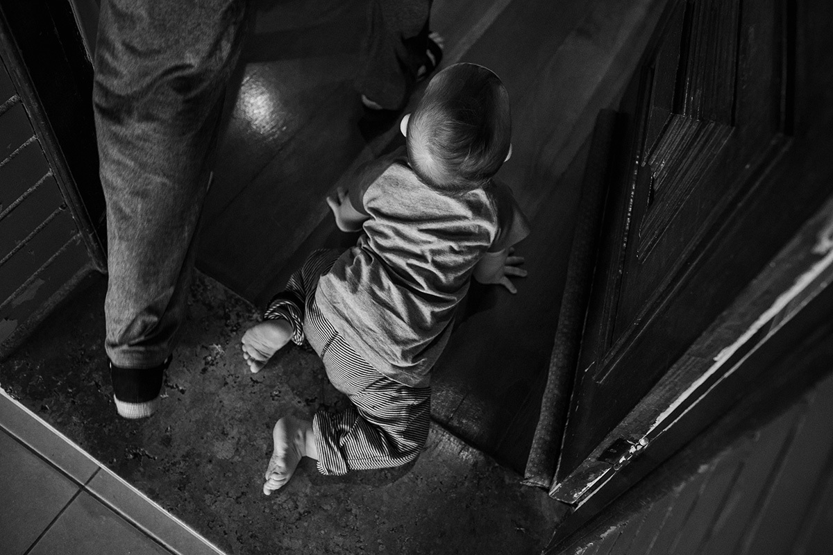 foto de Adriana Costa da mãe e filho entrando em casa, ele engatinhando