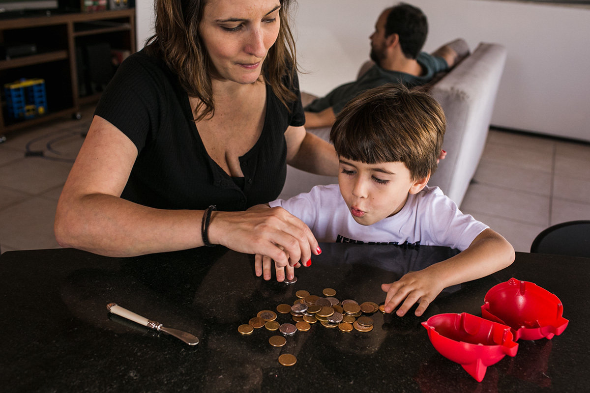 mãe e filho contando as moedas do cofre