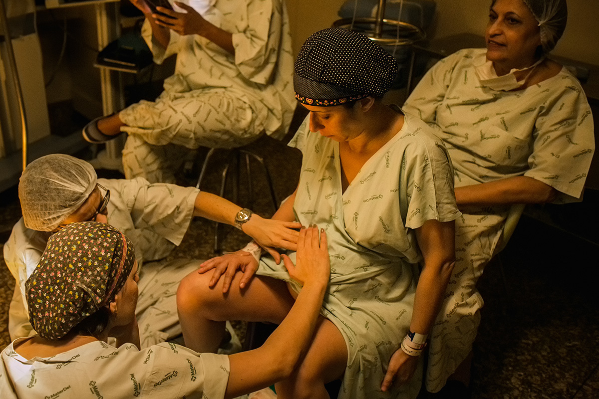 Gestante sendo examinada na sala de parto pela equipe do Instituto Nascer