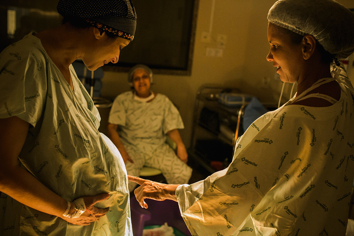 gestante, sua mãe e doula no momento do trabalho de parto, em foto de Adriana Costa