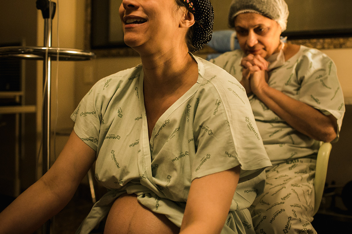 Foto de Adriana Costa da mãe rezando pela filha que está em trabalho de parto