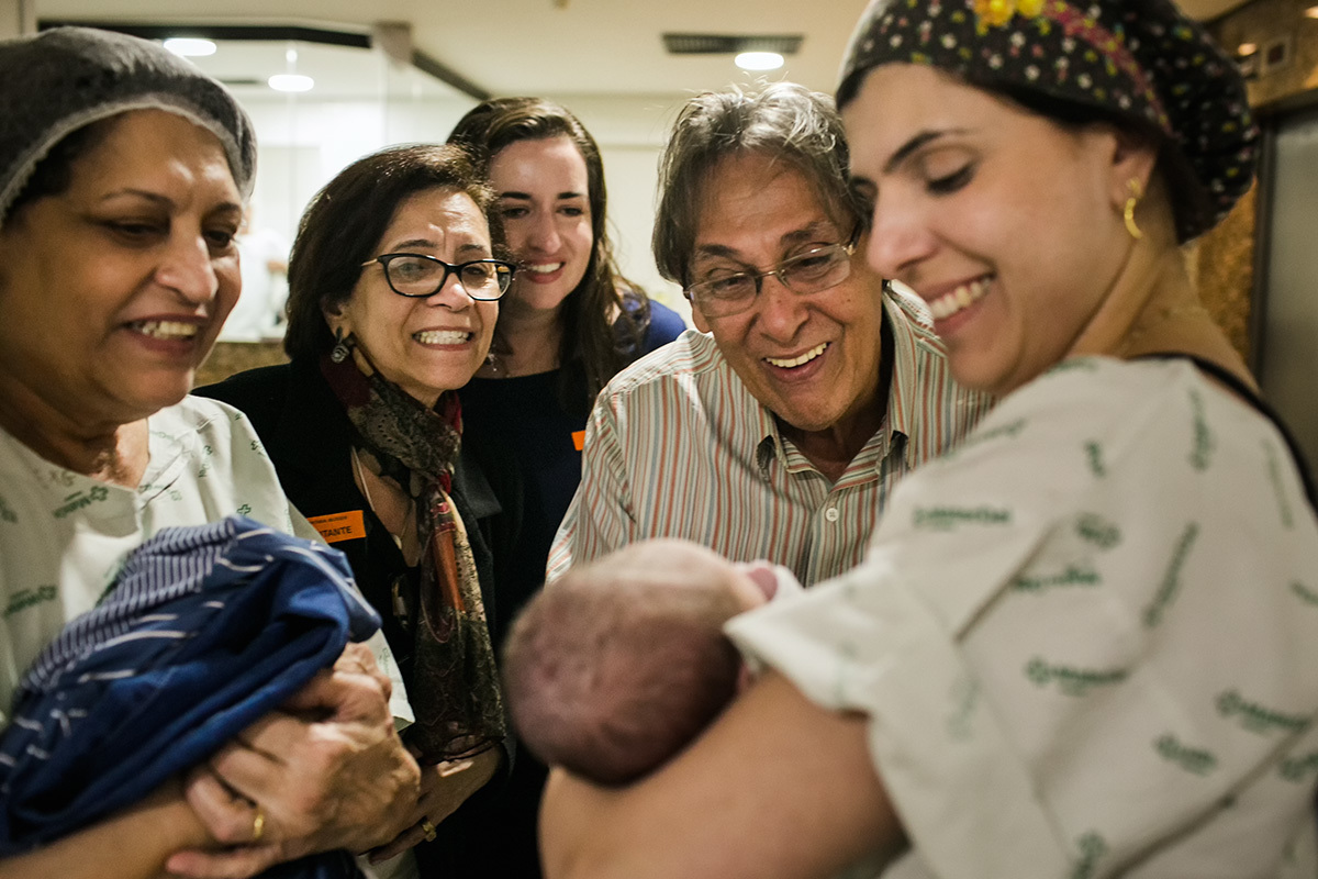 bebê sendo mostrado à família pela médica