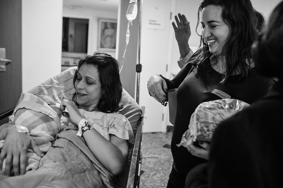 mãe e filha que acabou de nascer sendo recebidas pela família em foto de Adriana Costa