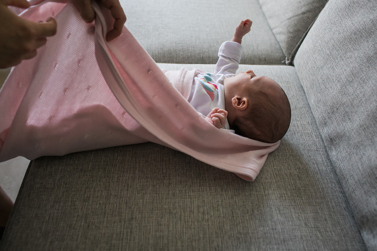 mãe enrolando sua bebê na manta