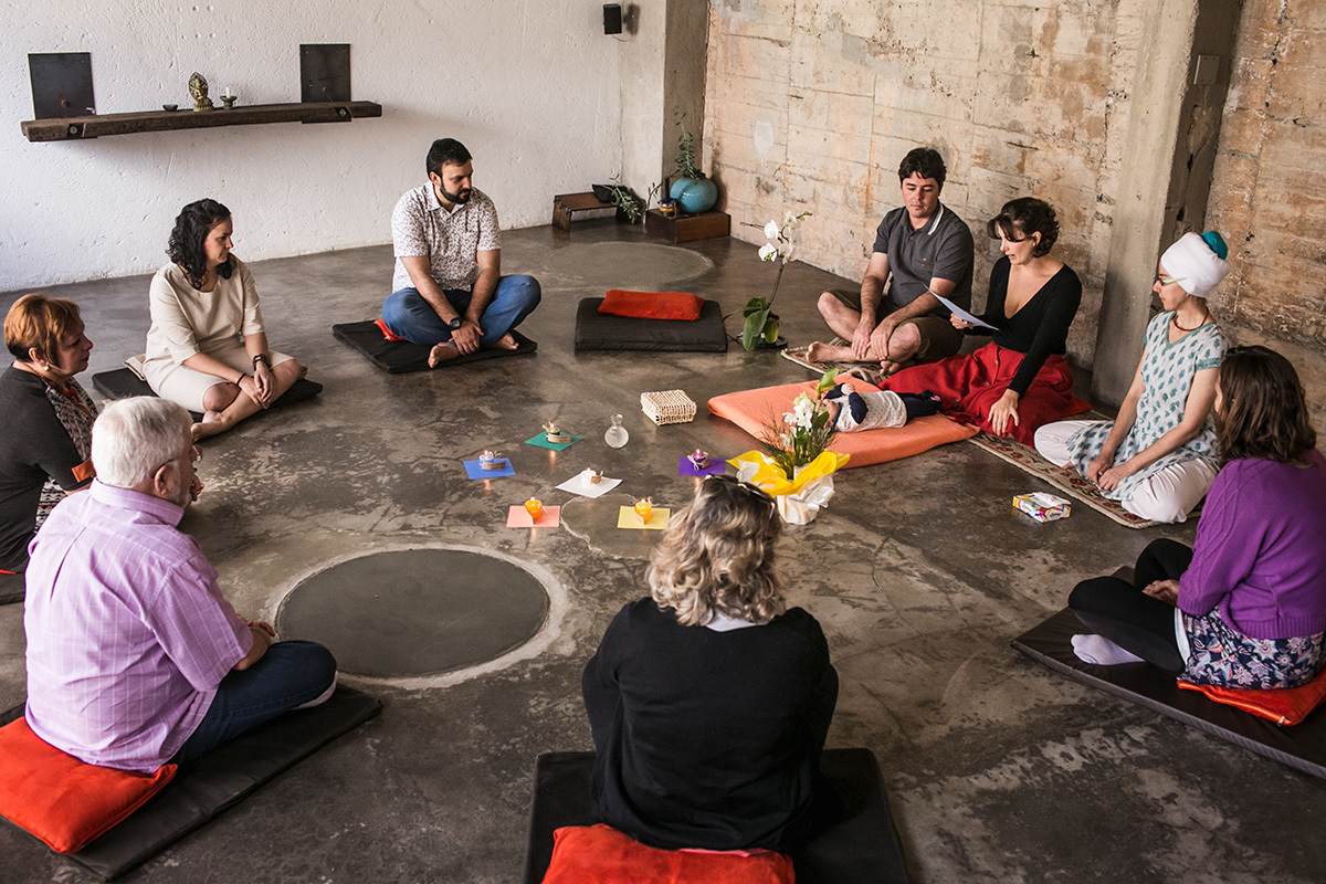 Adriana Costa fotografou a família sentada em circulo para a cerimônia de benção do bebê