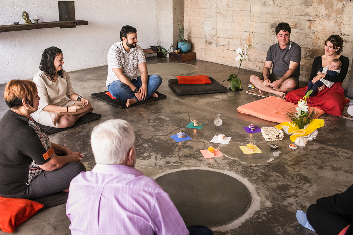 família reunida em círculo para abençoar a bebê da família
