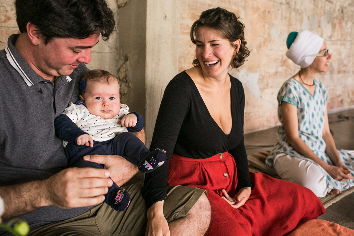 pais felizes com a filha no dia de abençoá-la