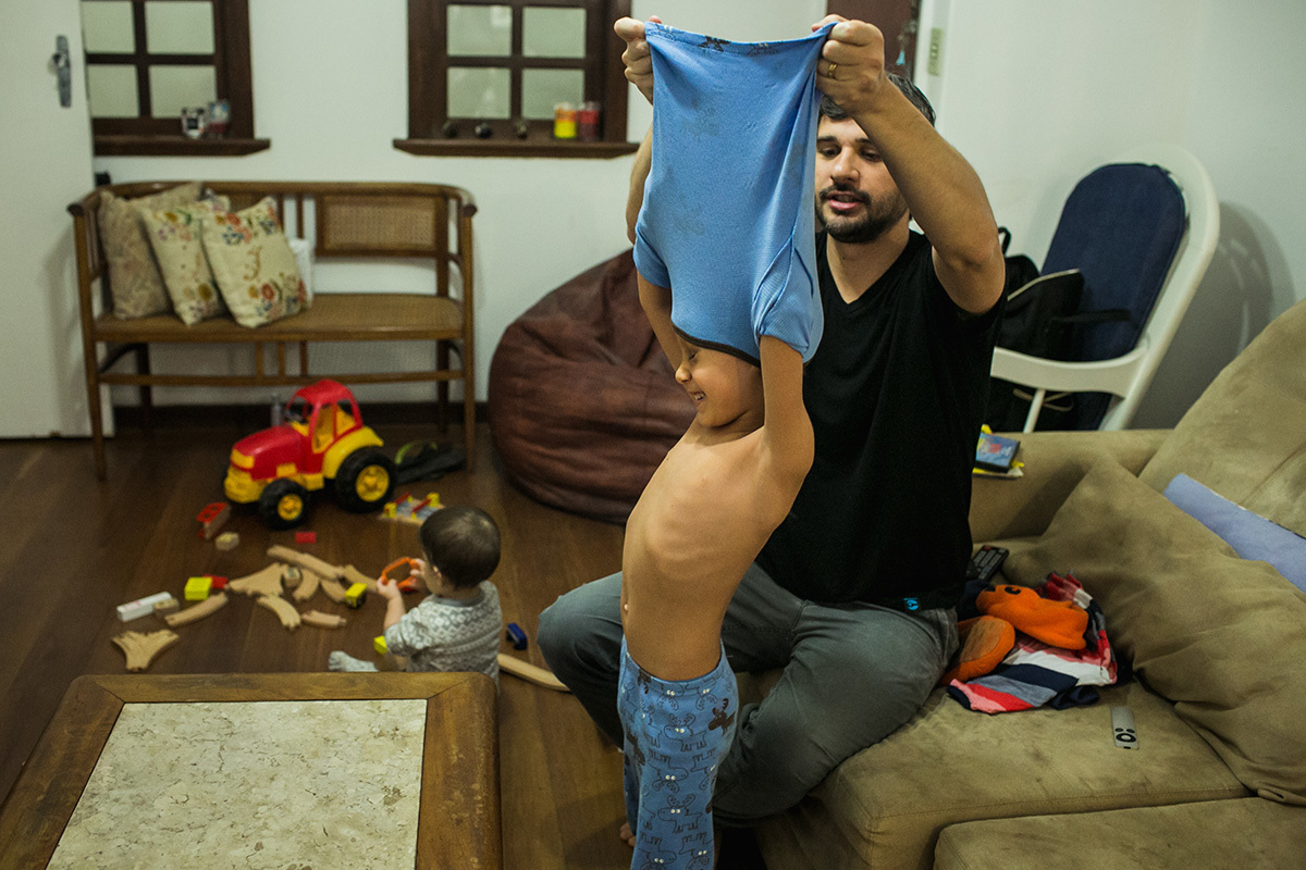 pai trocando a roupa de seu filho