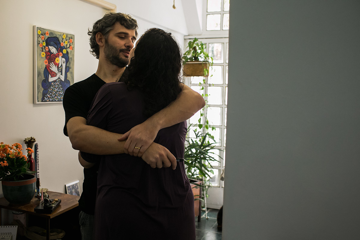 casal se abraçando diante do quadro do Artista Rogério Fernandes, por adrianacostafotos