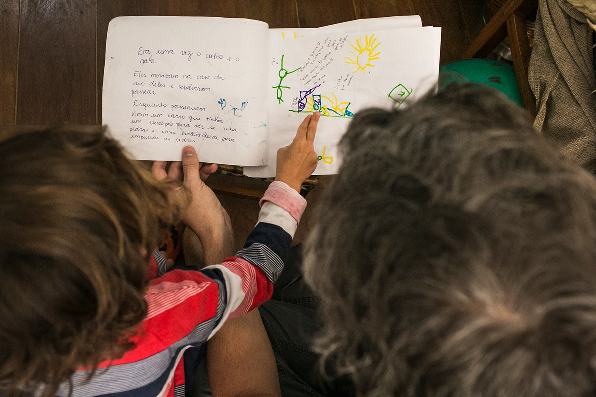 filho mostrando seu trabalho de escola para o pai
