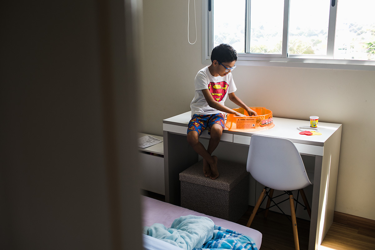 criança brincando de Beyblade em seu quarto, por adrianacostafotos