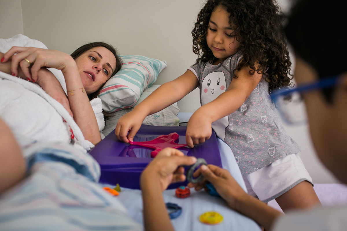 mãe em repouso observa seus filhos brincarem