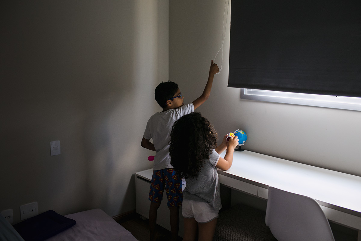 crianças fecham a cortina do quarto