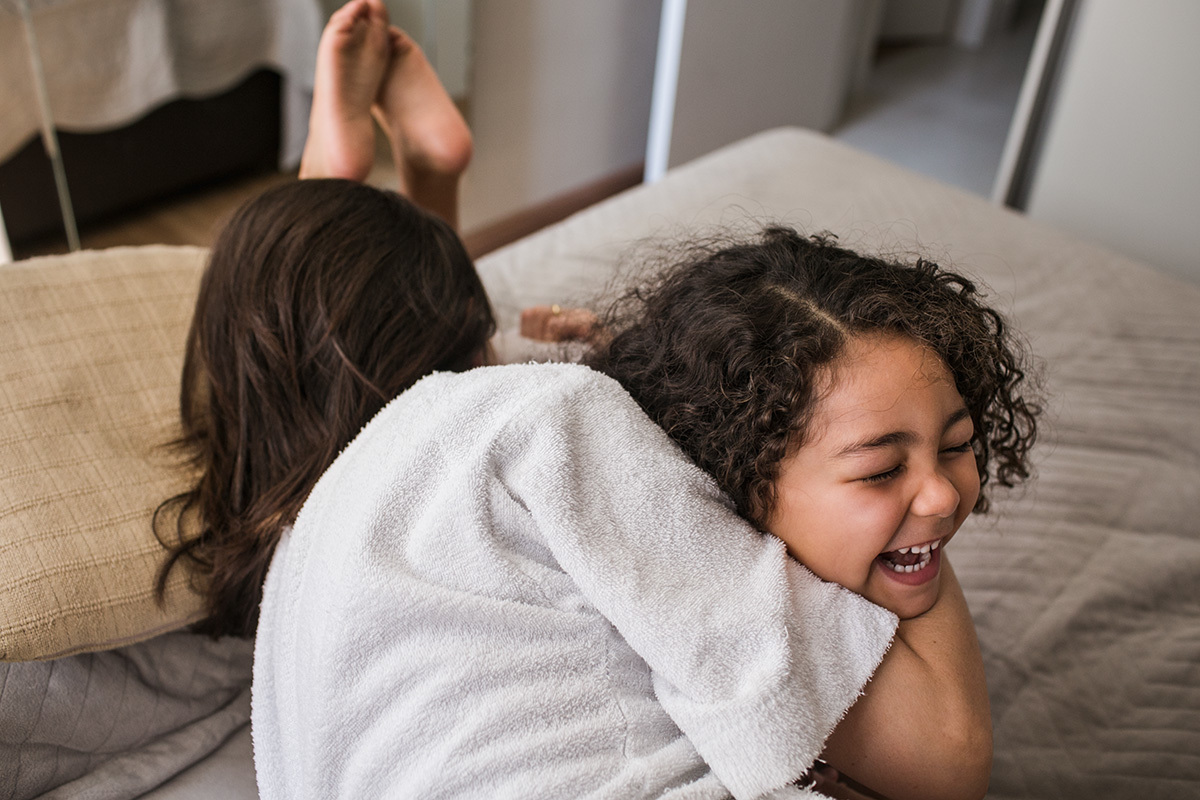 mãe e filha se abraçando com alegria, por Adriana Costa