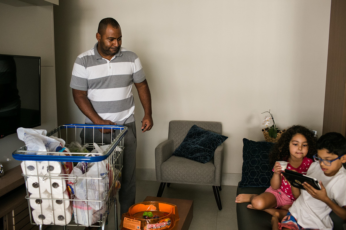 pai chegando em casa com o carrinho de supermercado