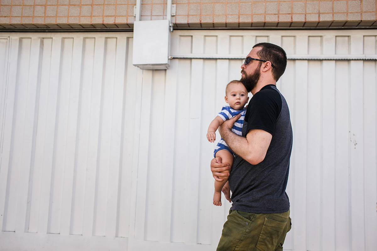 Pai indo para a padaria com seu bebê no colo