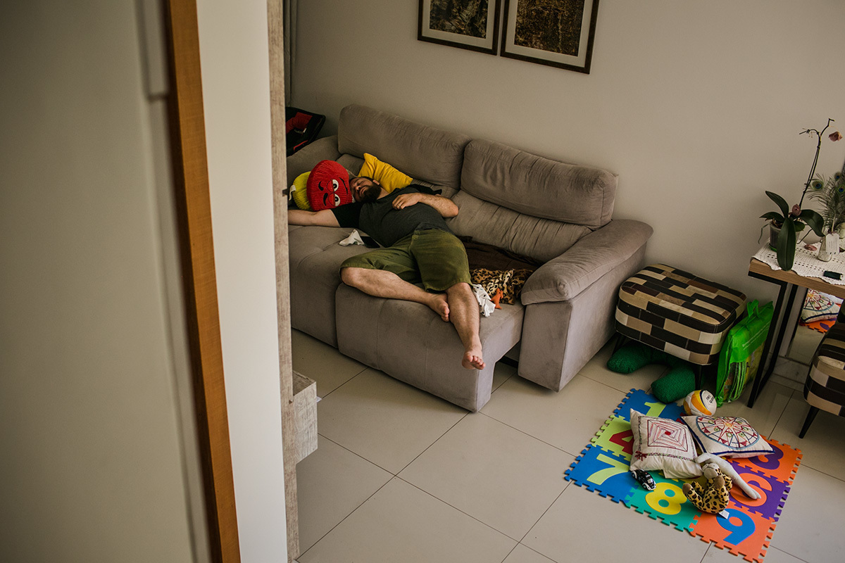 pai dormindo na sala enquanto seu bebê dorme no quarto