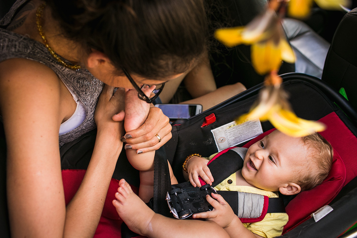 Adriana Costa fotografou mãe beijando o pé do seu bebê dentro do carro e ele super feliz com ela