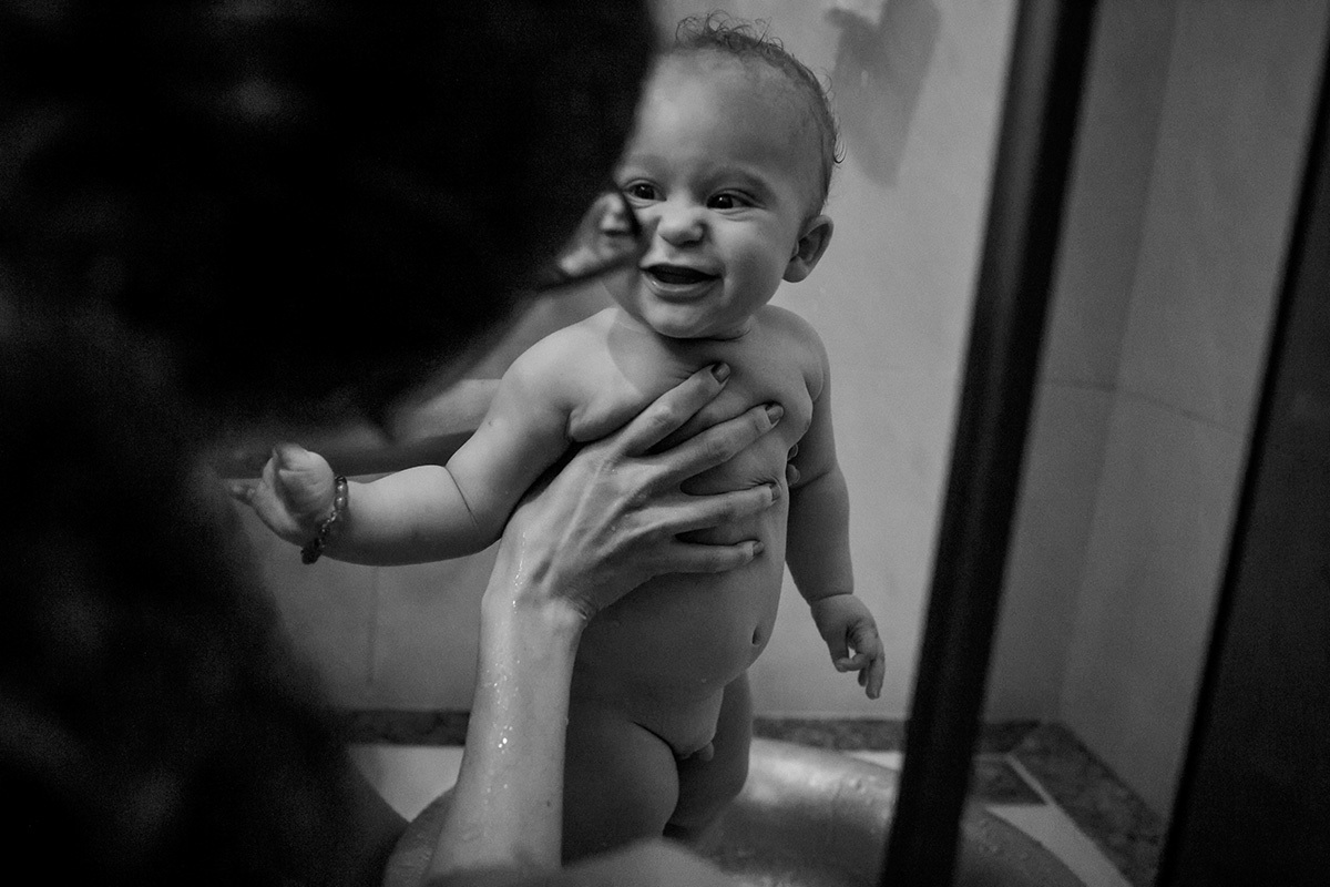 bebê feliz olhando para a mãe na hora do banho em foto de Adriana costa