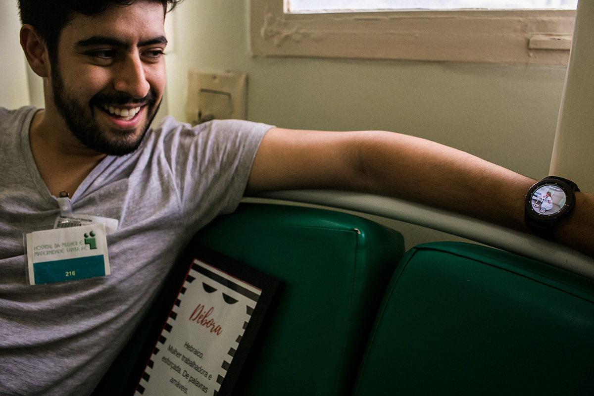 marido vendo pelo relógio a filmagem que fez da esposa em trabalho de parto