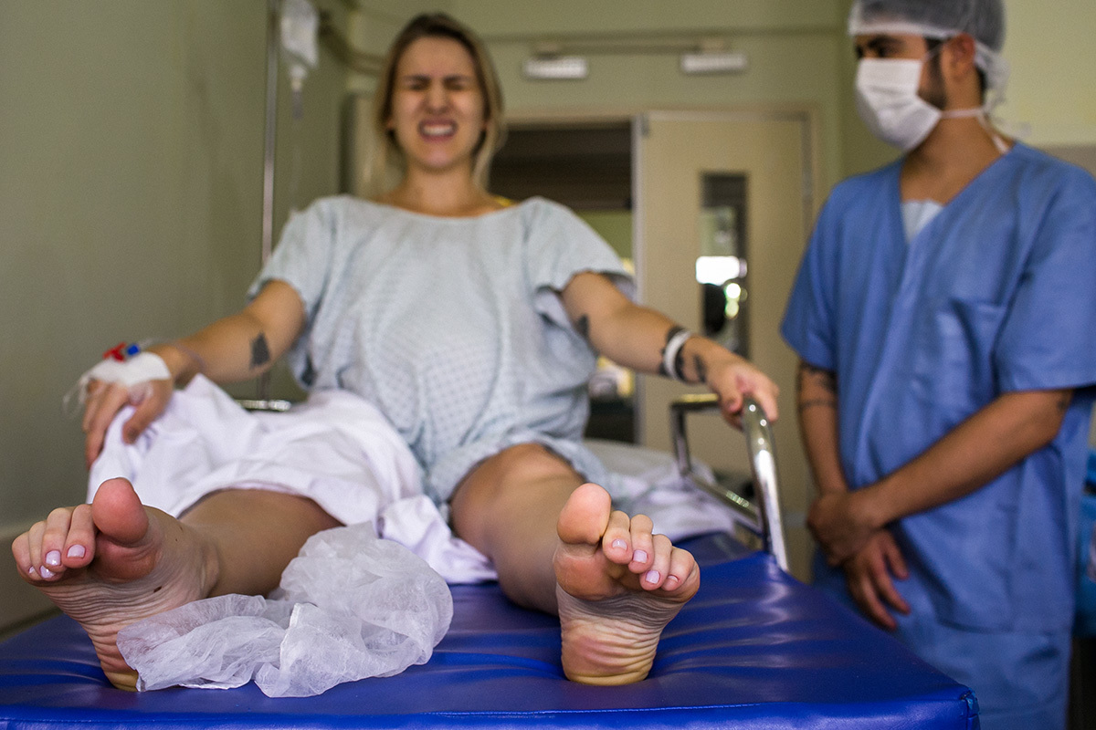 mulher tendo contrações fortes na sala de parto
