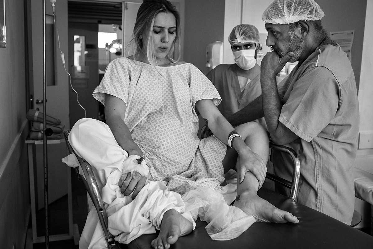 mulher sentada na maca à espera de nascer seu bebê