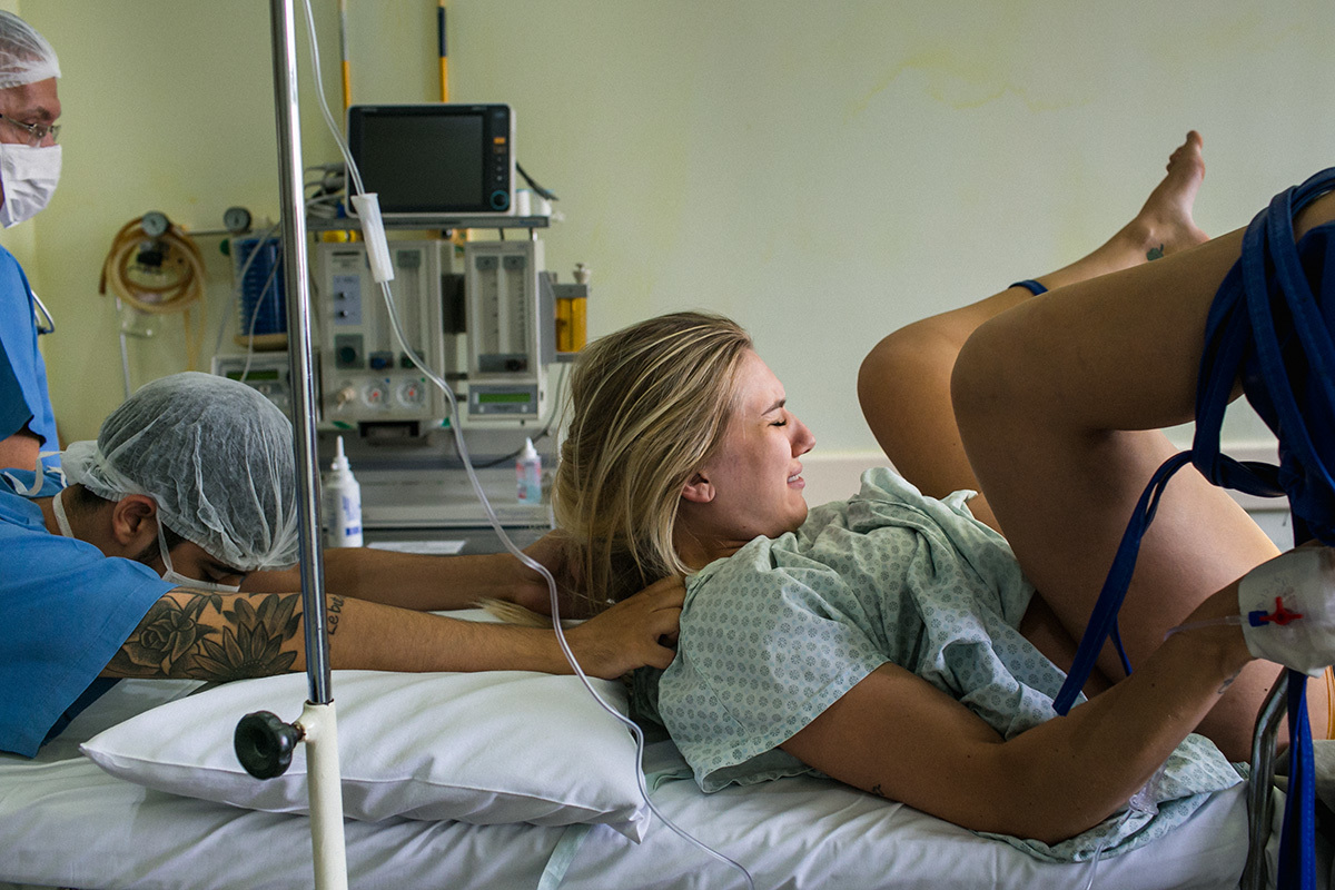 marido ajudando a esposa na hora do expulsivo durante um parto normal, em foto de Adriana Costa