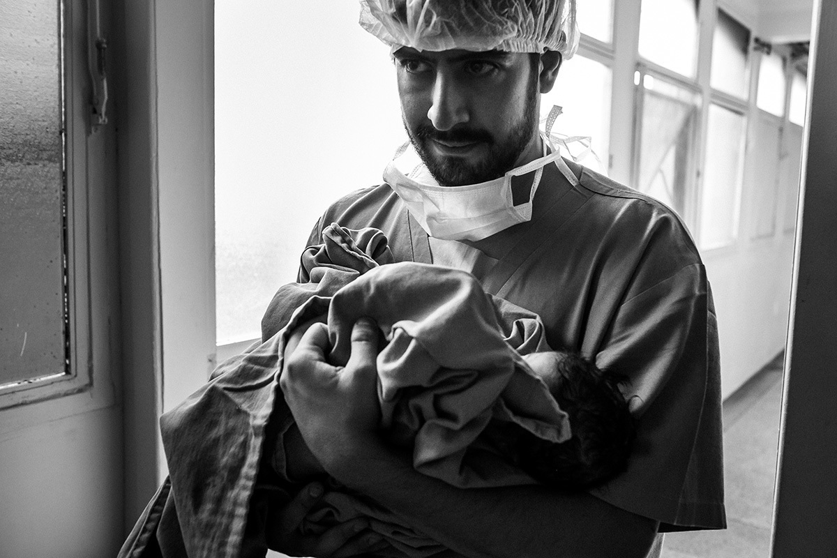 pai levando seu bebê que acabou de nascer para o berçário