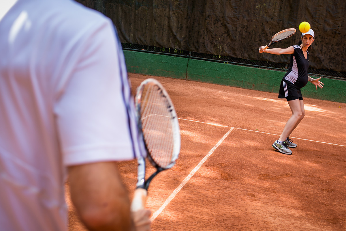 casal grávido jogando tênis